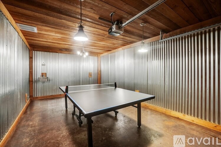 A ping pong table is in the middle of a room with wooden walls and a wooden ceiling.