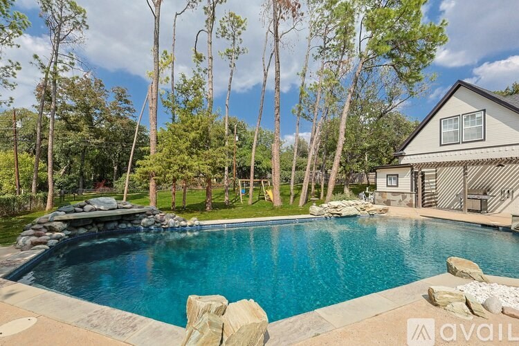 A house with a pool surrounded by trees.