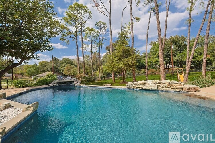 A swimming pool surrounded by trees and rocks.