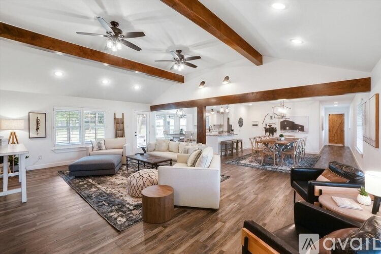 A spacious living room with wooden floors and furniture.