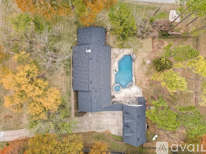 A house with a pool surrounded by trees.