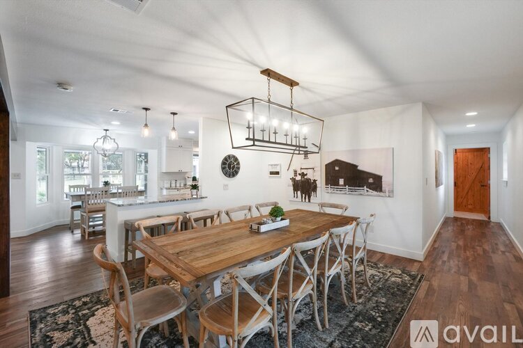 A modern dining room with a wooden table and chairs.