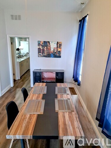 A dining room with a wooden table and chairs.