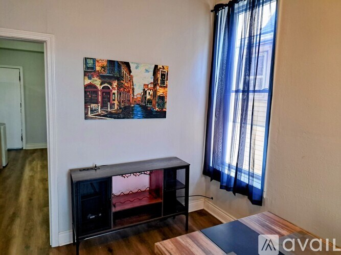 A living room with a fireplace and a painting on the wall.