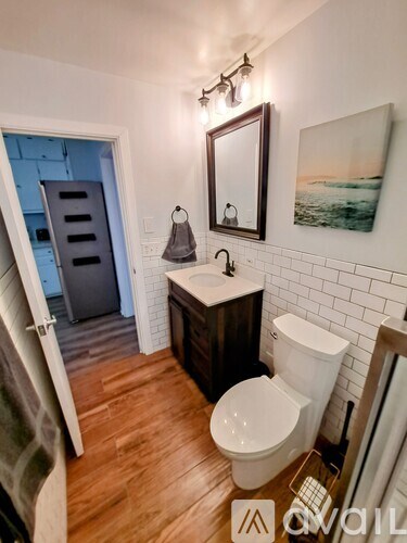 A small bathroom with a toilet, sink, and mirror.