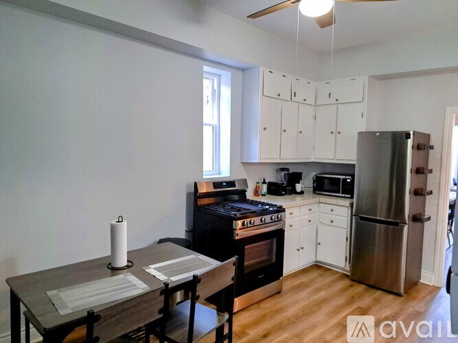 A kitchen with a table and chairs in front of it.