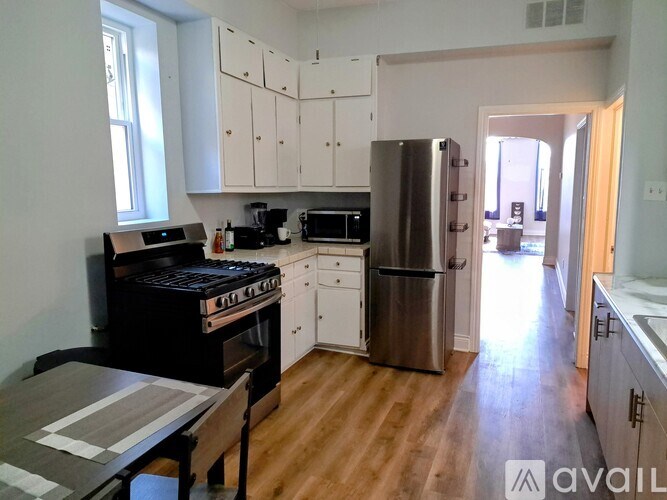 A kitchen with white cabinets and a black stove top oven.
