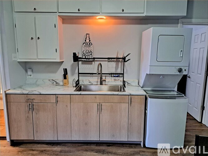 A kitchen with a sink, a dishwasher, and a refrigerator.