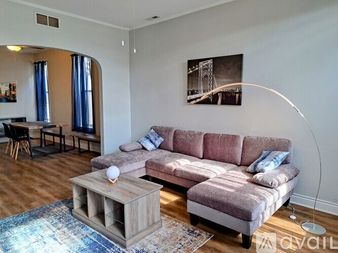 A living room with a pink couch and a wooden coffee table.