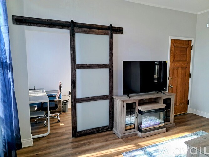 A room with a television and a sliding door.