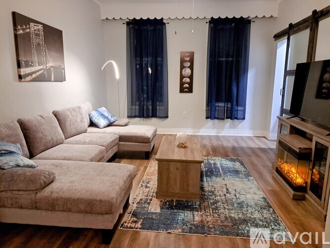 A living room with a couch, a coffee table, and a fireplace.