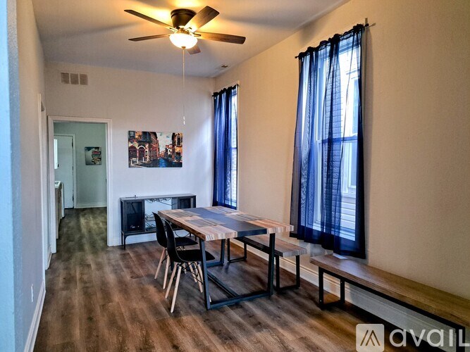 A room with a dining table and chairs.