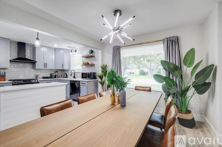 A modern kitchen with a wooden table and chairs.