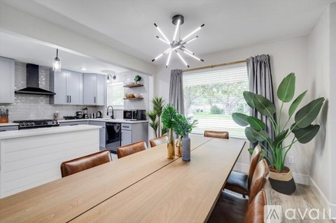 A modern kitchen with a wooden table and chairs.