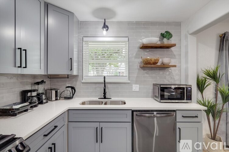 A kitchen with a white countertop and grey cabinets.