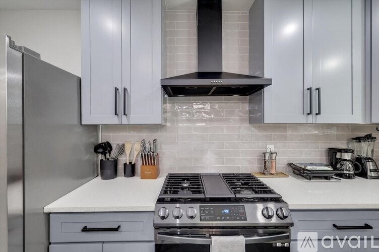 A modern kitchen with a stove top oven and a refrigerator.