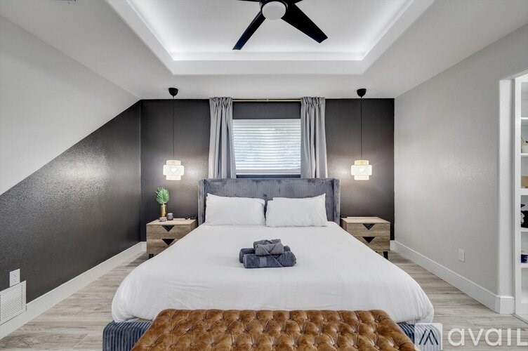 A bedroom with a large bed and a ceiling fan.