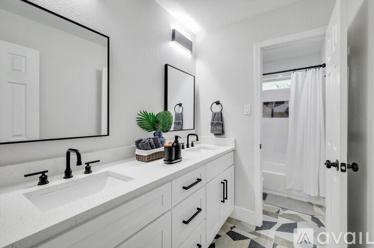 A bathroom with two sinks and a mirror above the counter.