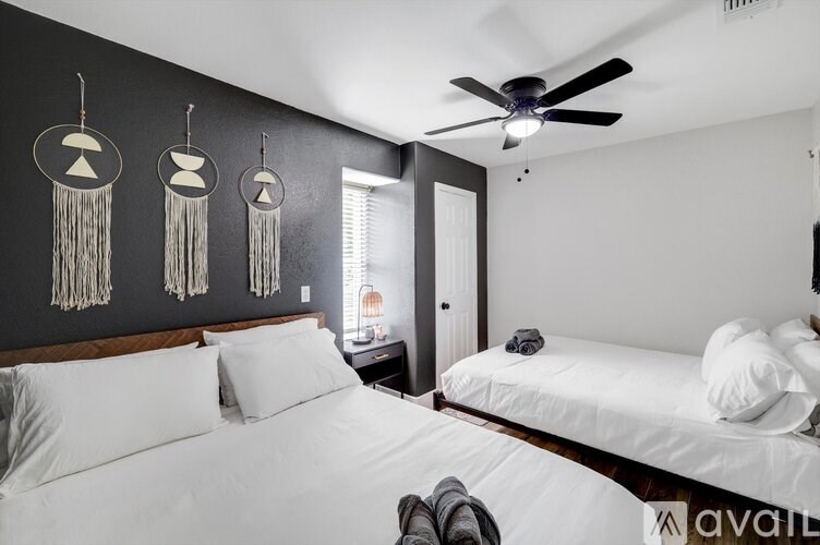 A bedroom with two beds and a ceiling fan.