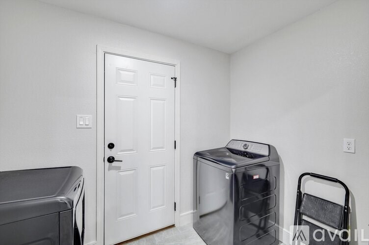 A room with a white door, a white wall, and a white floor.