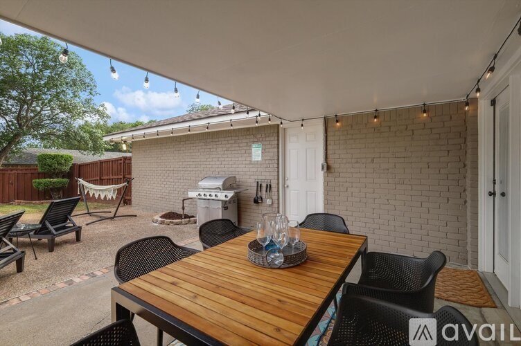 A patio with a wooden table and chairs is available for rent.
