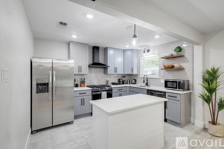 A modern kitchen with stainless steel appliances and white cabinetry.