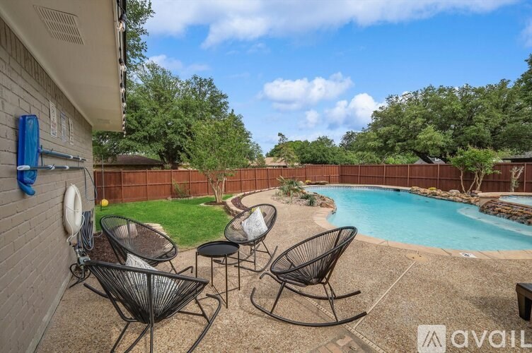 A backyard with a pool and patio furniture.
