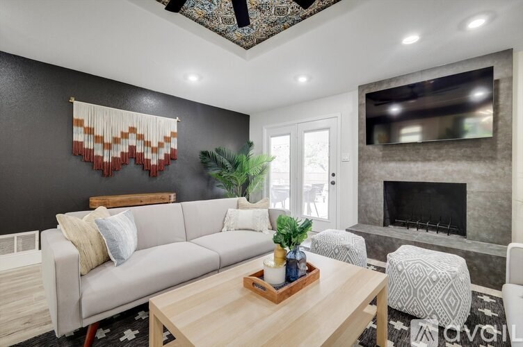 A living room with a grey couch, a wooden coffee table, and a fireplace.