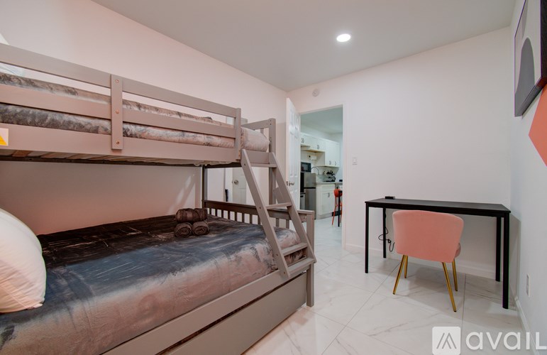 A bedroom with a bunk bed and a desk.