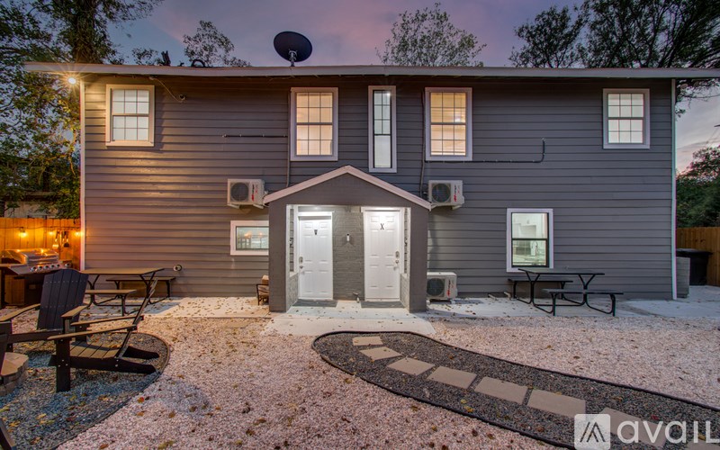 A house with a grey exterior and a patio with a table and chairs.