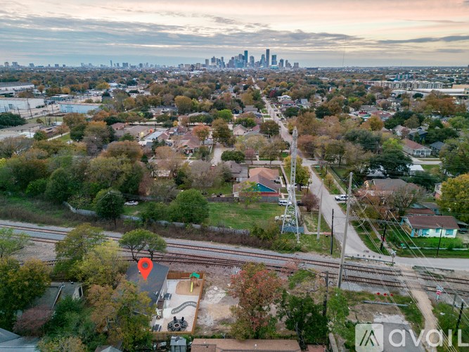 A suburban area with a train track and a city skyline in the distance.