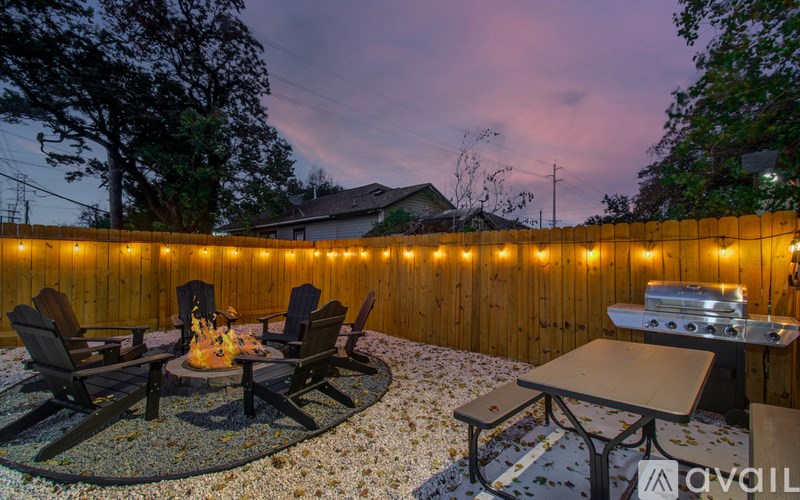 A backyard with a fire pit, chairs, and a picnic table.