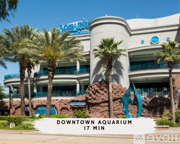 A large building with palm trees in front and a sign that says Downtown Aquarium.