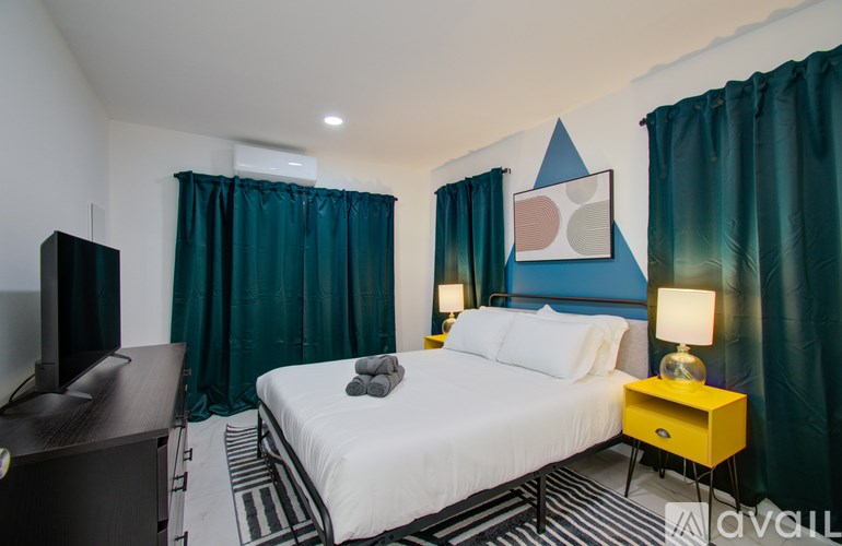 A bedroom with a bed, nightstand, and television.