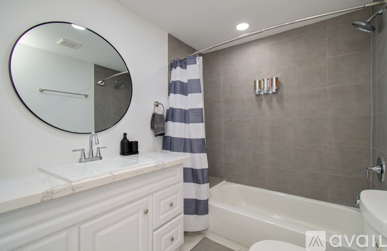 A bathroom with a white sink and a striped shower curtain.