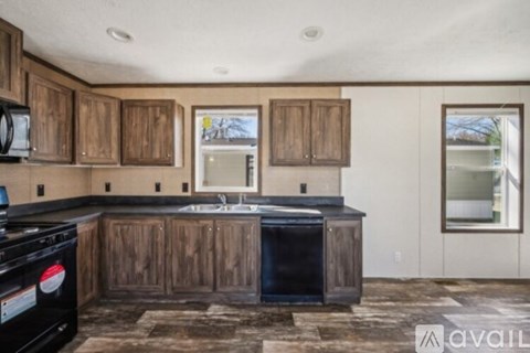 A kitchen with wooden cabinets and a black stove top oven.