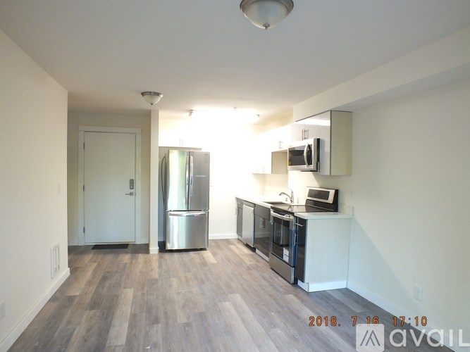 A kitchen with a refrigerator, microwave, and oven is available for rent.