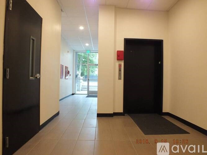 A hallway with two doors and a window in the background.