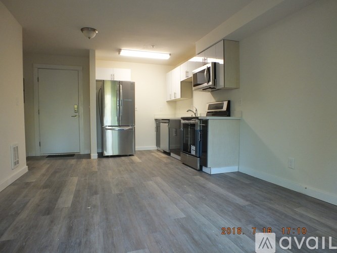 A kitchen area with a fridge, microwave, and oven.