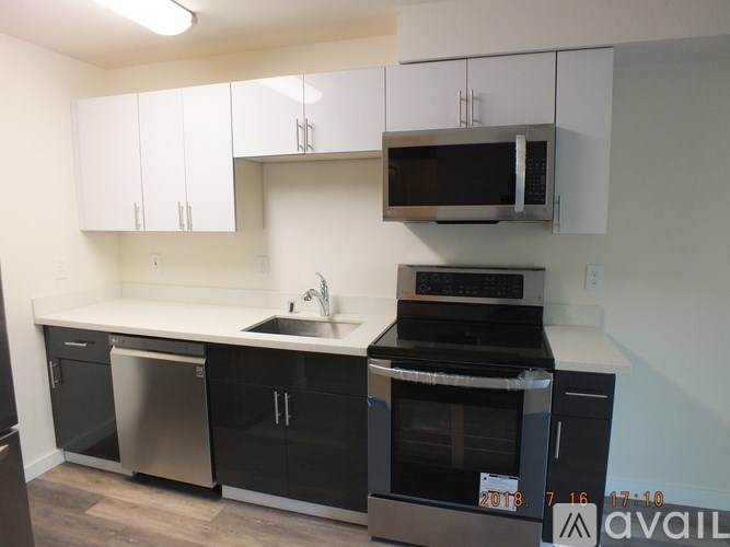 A kitchen with black cabinets and appliances is available for rent.
