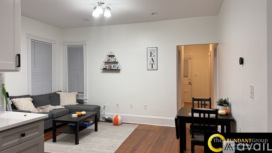 A living room with a couch, a table, and a ball on the floor.