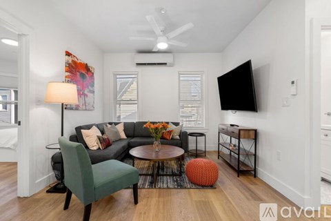 A living room with a green chair and a black TV.