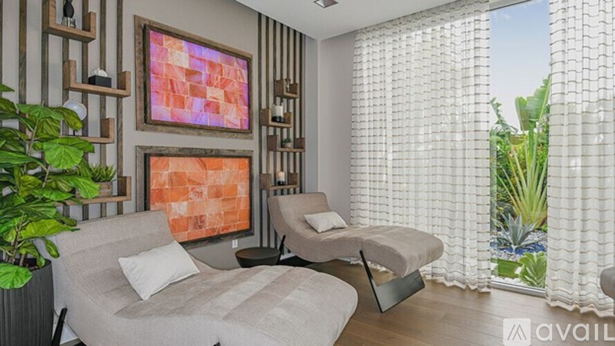 A bedroom with a bed and a couch with a painting on the wall.
