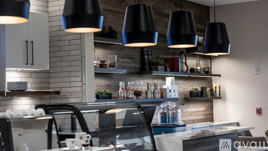 A modern kitchen with a bar area and pendant lights.