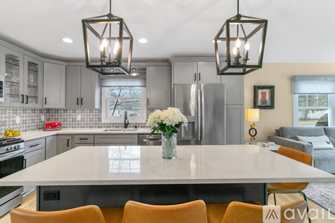 A kitchen with a table and chairs in the foreground and a refrigerator in the background.