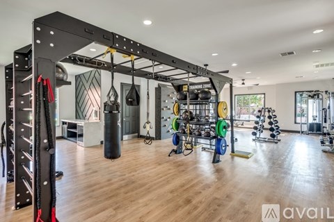 A gym with a variety of equipment including a punching bag and weight racks.