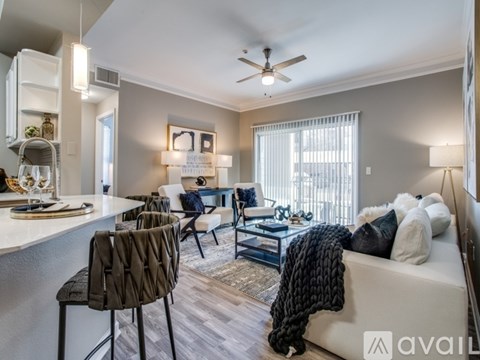 A living room with a white couch, a coffee table, and a ceiling fan.