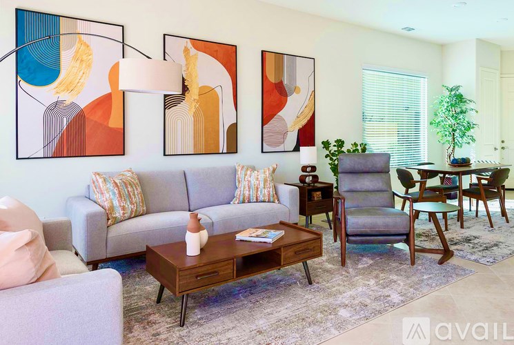 A living room with a grey couch, a brown coffee table, and a painting on the wall.