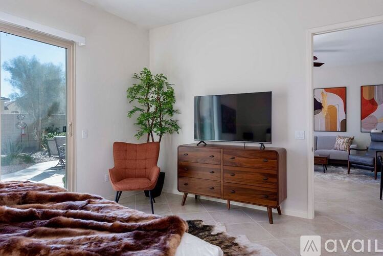 A living room with a brown chair and a brown dresser.