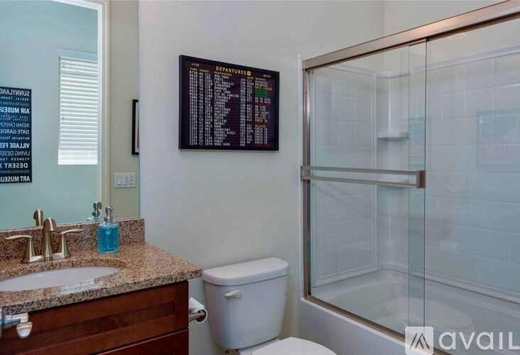 A bathroom with a toilet, sink, and shower.